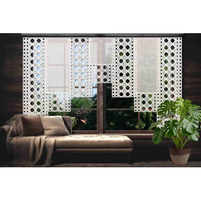 Ein modernes Wohnzimmer mit einer braunen Chaiselongue, einer gemütlichen Überwurfdecke, einer großen Topfpflanze und einem Fenster, das mit der Flächengardine Miray mit Vogtländischer Spitze geschmückt ist und das Grün durch die geometrischen weißen Vorhänge scheinen lässt.