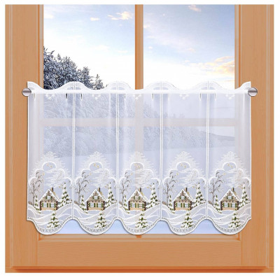 Ein hauchdünner, weißer Scheibenhänger mit aufgestickten Winterhäuschen und -bäumen hängt an einem Holzfenster; draußen sorgen schneebedeckte Bäume für eine sonnenbeschienene Winterlandschaft. Diese Advents-Scheibengardine bringt weihnachtlichen Charme ins Haus.