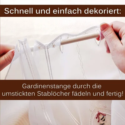 Nahaufnahme von Händen, die eine Gardinenstange durch eine weiße Scheibengardine mit gestickten Schlaufen fädeln. Der Text auf Deutsch lautet: „Schnell und einfach dekoriert: Gardinenstange einfach durch die umstickten Stablöcher fädeln und fertig!“.