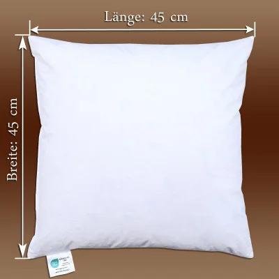 Ein quadratisches weißes Kisseninlett mit den Maßen 45 cm (Länge und Breite) auf braunem Hintergrund mit Pfeilen und Text zur Größenangabe. In der unteren linken Ecke befindet sich ein kleines Schild.