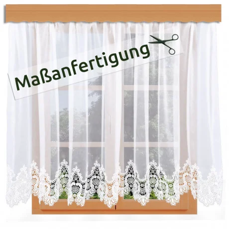 Weiße Spitzenvorhänge mit einem verschnörkelten Blumenmuster hängen an einer Holzstange vor einem Fenster. Ein Etikett mit einem Scherensymbol und dem Wort "Maßanfertigung" befindet sich oben links auf dem Bild.