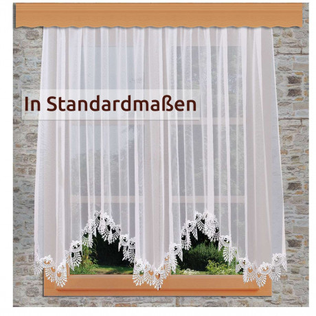 Ein Fenster mit durchsichtigen weißen Spitzenvorhängen, die eine florale Kante aufweisen. Draußen sind grünes Gras und Pflanzen zu sehen. Der Text auf dem Vorhang lautet: "In Standardmaßen. Ein Fenster mit durchsichtigen weißen Spitzenvorhängen, die eine florale Kante aufweisen. Draußen sind grünes Gras und Pflanzen zu sehen. Der Text auf dem Vorhang lautet: "In Standardmaßen.