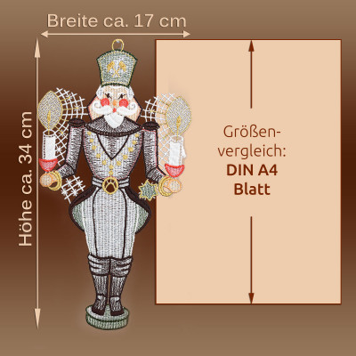 Ein Bergmann-Fensterbild, etwa 34 cm hoch und 17 cm breit, steht zum Größenvergleich neben einem A4-Blatt. Es eignet sich perfekt als Weihnachtsdekoration und steht vor einem braunen Hintergrund mit deutschem Text, in dem die Maße angegeben sind.