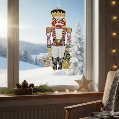 Ein festliches Fensterbild Nussknacker Ornament hängt im Fenster mit verschneiten Blick nach draußen. Tannenzapfen, eine brennende Kerze und ein Stern schmücken die Fensterbank und machen diese Weihnachtsdekoration perfekt für eine gemütliche Winteratmosphäre.