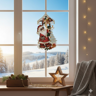 Eine gemütliche Winterszene mit einem dekorierten Fenster, das eine verschneite Landschaft zeigt. Ein festliches Fensterbild Weihnachtsmann Ornament hängt am Fenster. Eine leuchtende Sternlampe, Tannendekoration und eine graue Decke liegen auf der Fensterbank und dem Stuhl.