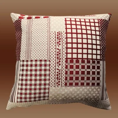 Kissenhülle Patchwork-Optik 40 x 40 cm rot-beige mit Füllung dargestellt vor braunem Hintergrund