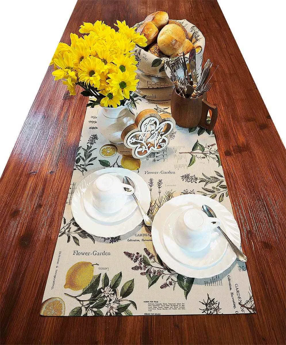Tischläufer Liora Kräutercharme auf einem Holztisch mit Blumen und Geschirr dekoriert